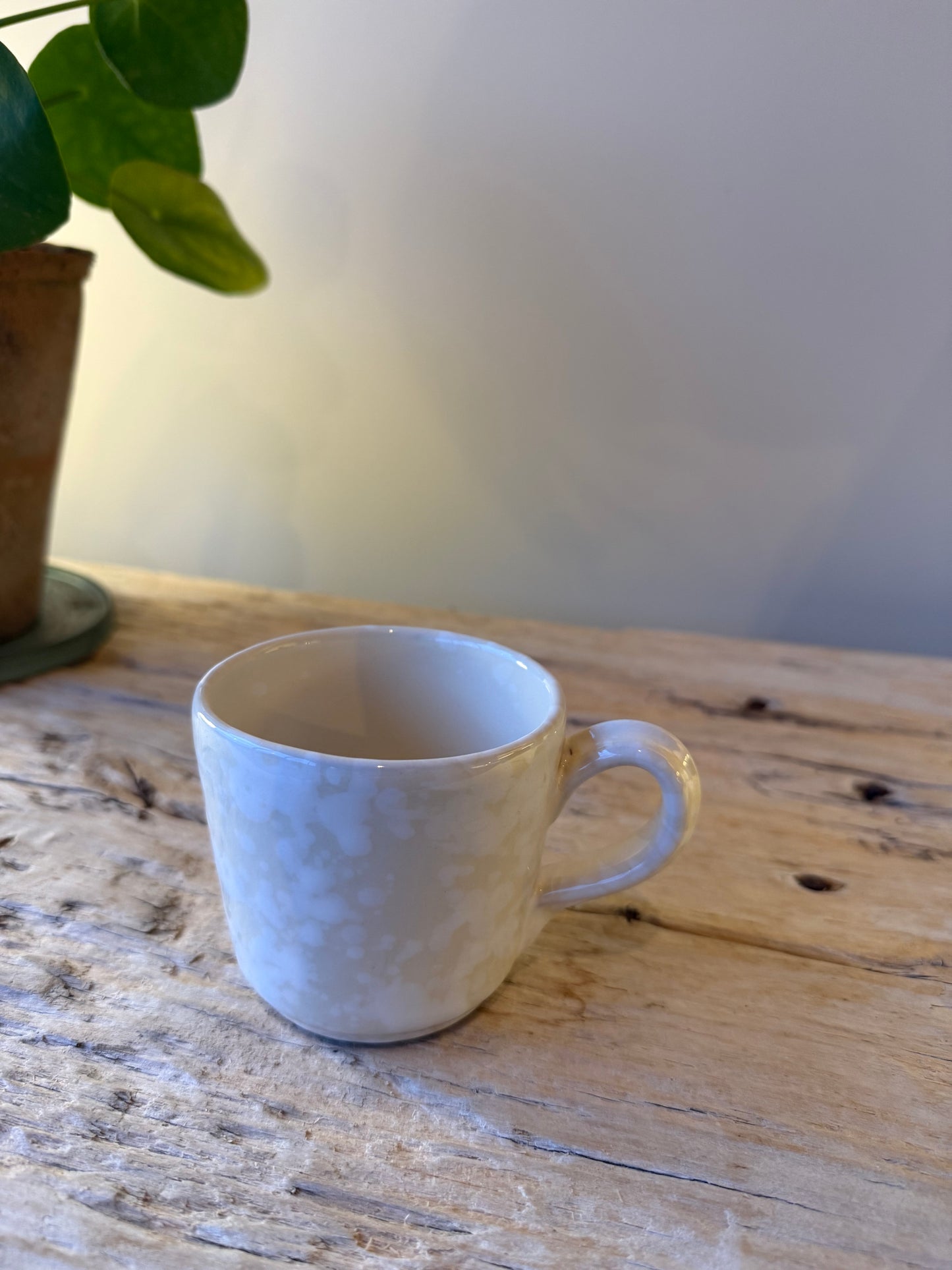 Pale stone & white splatterware cup